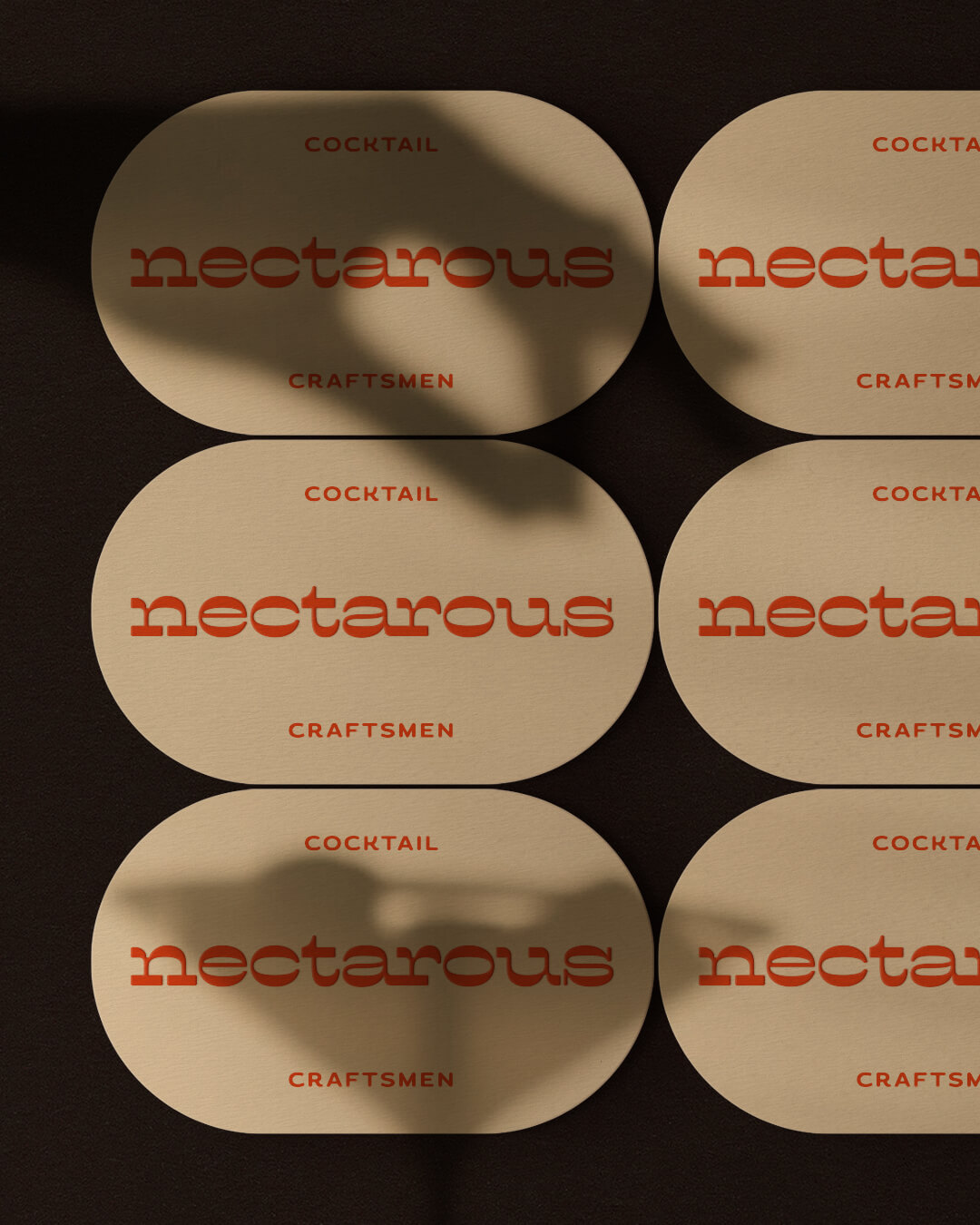 Martini glass shadow cast across rounded business card designs with embossed 'Nectarous' logo for an Australian mixology service.